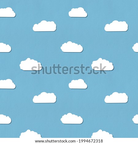 Seamless pattern. Cute clouds pattern on a blue paper background. 