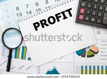 PROFIT.The calculator,a magnifying glass, notebook with the text on the financial table. Business, Financial concept