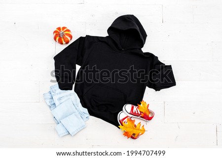 Blank flat lay black kids hoodie on white background with fall props, unisex halloween apparel mockup