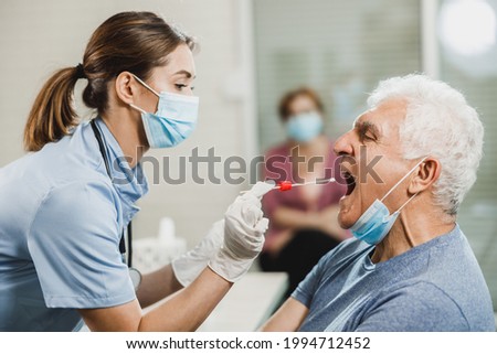 A senior man having swab medical test from throat during coronavirus pandemic.