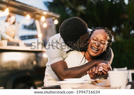 African mother and son having fun together outdoor at food truck restaurant - Love and family lifestyle concept - Focus on mum face Royalty-Free Stock Photo #1994716634