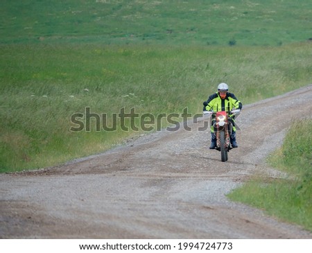 a motor cyclist (biker) riding his motorbike along a stone track on Salisbury Plain, Wiltshire