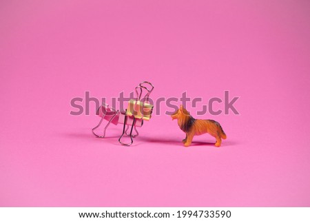 Two dogs on trendy pink background. Kids toy dog and dog made of steel binder clips. Futuristic looking toy. Friends idea. Minimal abstract playing concept.