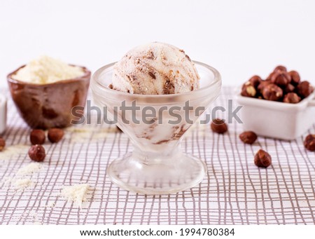 Powdered milk ice cream with chocolate in a glass with ingredients used to decorate the background