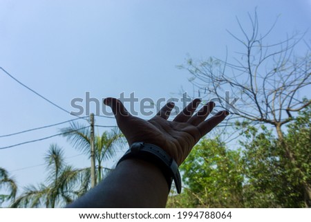one hand on this image and in hand wearing watch , hand open in background blur
