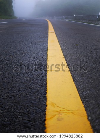 yellow stripe line painted on the asphalt road for traffic sign