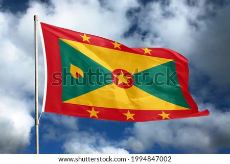 Grenada flag on sky and cloud background. National symbols of Grenada. Flag of Grenada.