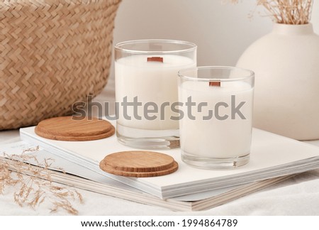 Handmade scented candles in a glass with a wooden lid. Soy wax candles with a wooden wick. Royalty-Free Stock Photo #1994864789