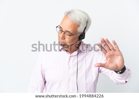 Telemarketer Middle age man working with a headset isolated on white background making stop gesture and disappointed