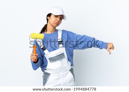 Painter woman over isolated white background showing thumb down with negative expression