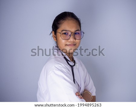 Portrait of a female doctor wearing glasses Standing with arms crossed on a white background.