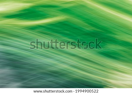 Green-yellow abstract background. Imitation of mountain grass covered hills. Photo created by camera movement at long exposure.