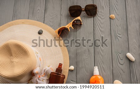 beachwear hat sun protection sunglasses sunscreen spray lotion body care tan ultra-violet rays. Summer background template mockup free space composition sample text. Top view above wooden background