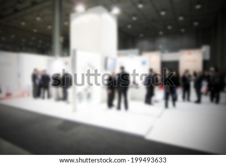 Trade show with people, intentionally blurred post production background.