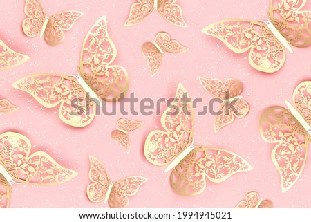Festive background made with gold tracery illuminating butterflies and with shiny confetti on pink. Holiday concept. Top view Template for your design.