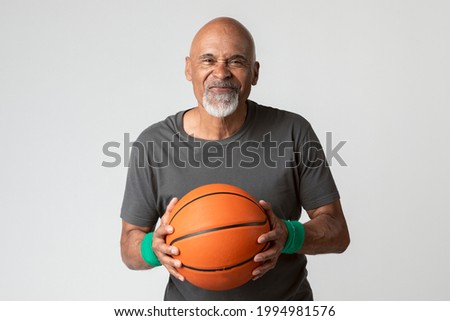 Happy senior man holding a basketball