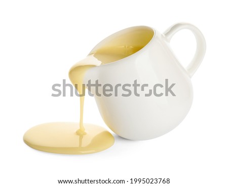 Jug with sweet condensed milk on white background Royalty-Free Stock Photo #1995023768
