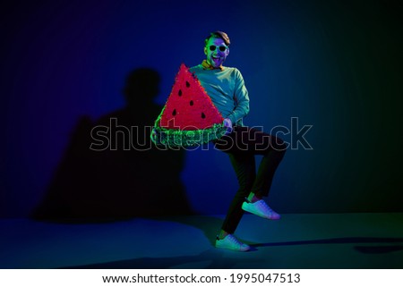 Full length body size photo guy wearing sunglass keeping watermelon paper collage at party isolated dark blue color background