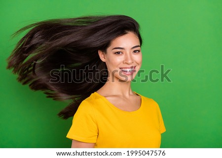 Photo portrait of girl with long brunette hair flying on wind smiling overjoyed isolated on bright green color background copyspace