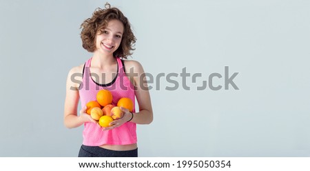 Banner for text about diet and nutrition, where is young woman with citrus fruits on a gray background.