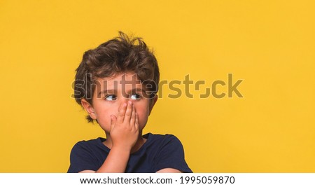 Excited amazed shocked or surprised child boy face isolated on yellow background. Funny kid portrait with big eyes and open mouth.  
