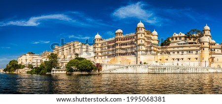 Panorama of famous romantic luxury Rajasthan indian tourist landmark - Udaipur City Palace on sunset with cloudy sky - surface level view. Udaipur, Rajasthan, India Royalty-Free Stock Photo #1995068381