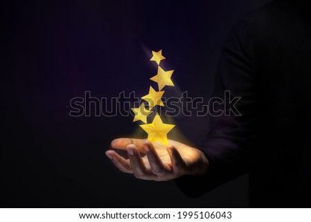 Success in Business or Personal Talent Concept. Gesture Hand with Golden Five Star Awards Royalty-Free Stock Photo #1995106043