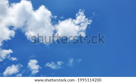 White fluffy clouds in the blue sky. Cloudscape photo, can be used as background with copy space. Concept of freedom and relaxation.