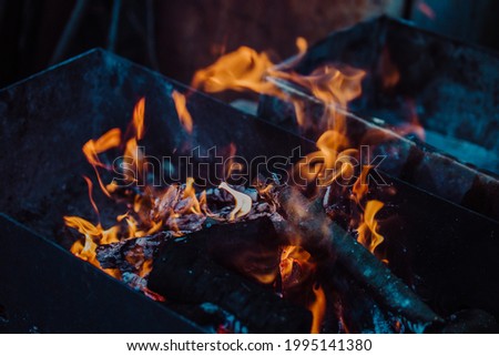burning firewood in the grill in dark gloomy colors.