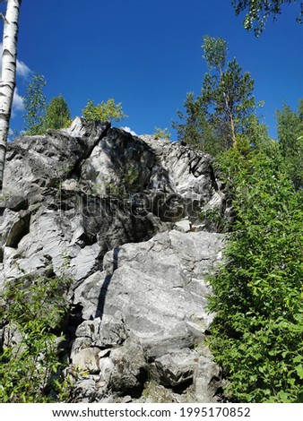 Catherine's marble cliff surrounded by trees in Ruskeala Mountain Park on a sunny summer day.