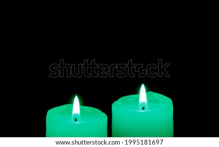 Glowing a pair of mint green candles in the dark with copy space
