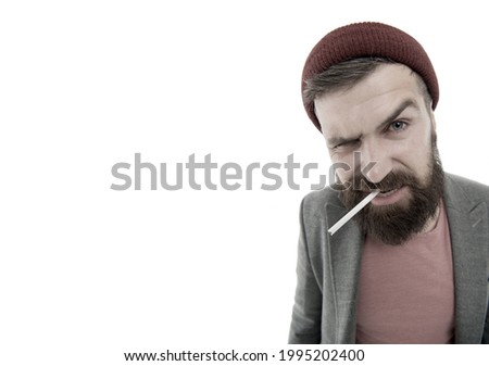 Brutal unshaven guy smoking isolated white background. Brutal habits and lifestyle of tramp. Hipster brutal bearded tobacco smoker. Man brutal bearded hipster dressed as vagabond smoking cigarette