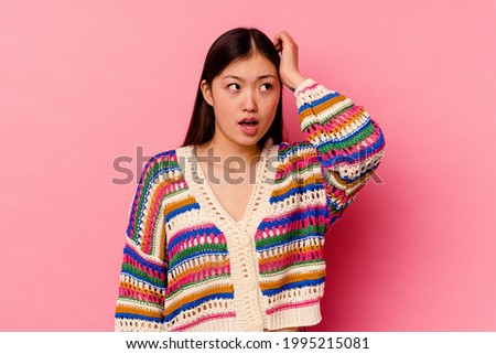 Young chinese woman isolated on pink background being shocked, she has remembered important meeting.