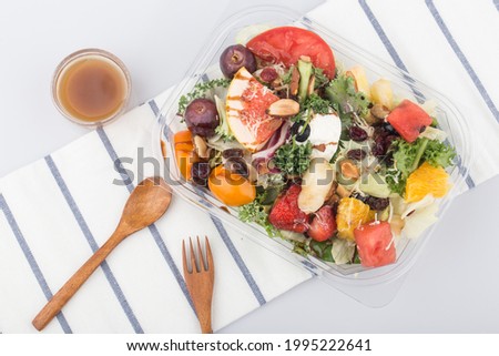Fruit and vegetable salad in a package on white table