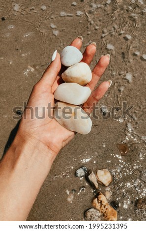 Woman hand manicure holding white beautiful stones above sea sandy summer beach. Natural background. Girl keep on palm sea pebbles.
Template free space pattern wallpaper mockup. Summer background. 