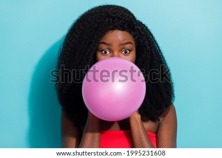 Photo of funky young dark skin woman blow balloon festive mood face isolated on teal color background