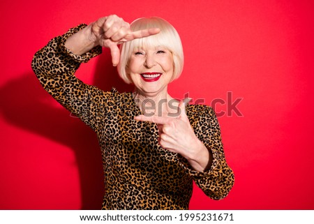 Photo of happy creative old charming woman hold fingers frame camera smile isolated on red color background