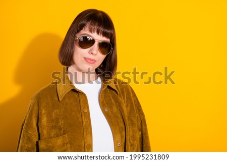 Photo of sweet confident young woman dressed cowboy clothes dark spectacles empty space isolated yellow color background