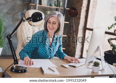 Photo of happy nice pretty old woman smile good mood work paper indoors inside house workplace workstation