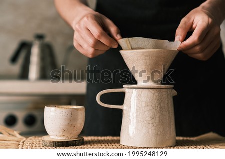 Brewing pourover coffee in the kitchen with a custom made filter Royalty-Free Stock Photo #1995248129