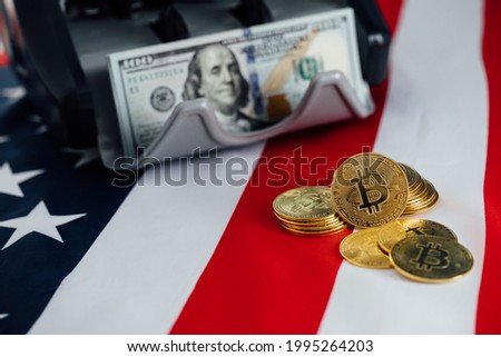 Close up of Bitcoin coins crypto currency money of the future with dollars banknotes on American USA flag background. Concept of economic crisis.