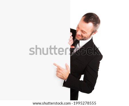 Smiling businessman pointing at blank sign