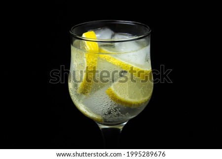 Refreshing cocktail with ice and lemon on a black background. Non-alcoholic cocktail.