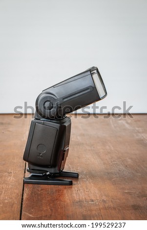 Photo camera flash on brown desk