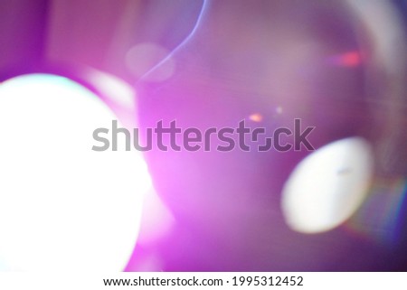 Abstract background with blurred purple bokeh defocused lights on dark grey background. Glow in the dark theme. (space for text design)
