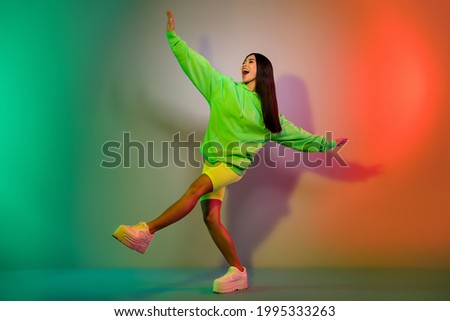 Full length body size view of attractive cheerful girl dancing resting isolated over multicolor vivid neon light background