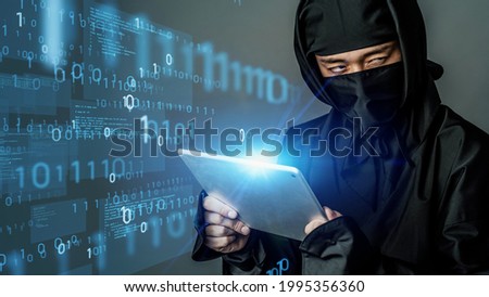 Japanese ninja using a tablet pc. Industrial spy. Cyber terrorism. Royalty-Free Stock Photo #1995356360