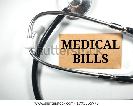 Medical concept.Text MEDICAL BILLS with stethoscope on white background