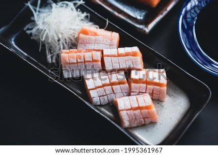 Salmon Sashimi with belly, Japanese buffet restaurant.Fresh salmon fillet on black plate salmon slices.Asian people eating sashimi set Japan restaurant.salmon sashimi.Asian Food Menu.seafood sashimi.