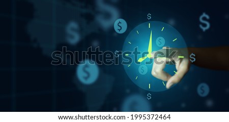 Business time management. Businessman hand pointing clock and money sign or icon on deep blue background. Business time is Money concept. Royalty-Free Stock Photo #1995372464